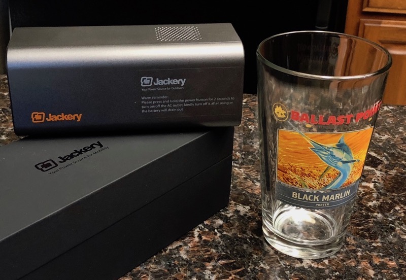 Jackery PowerBar on side with Ballast Point Black Marlin pint glass