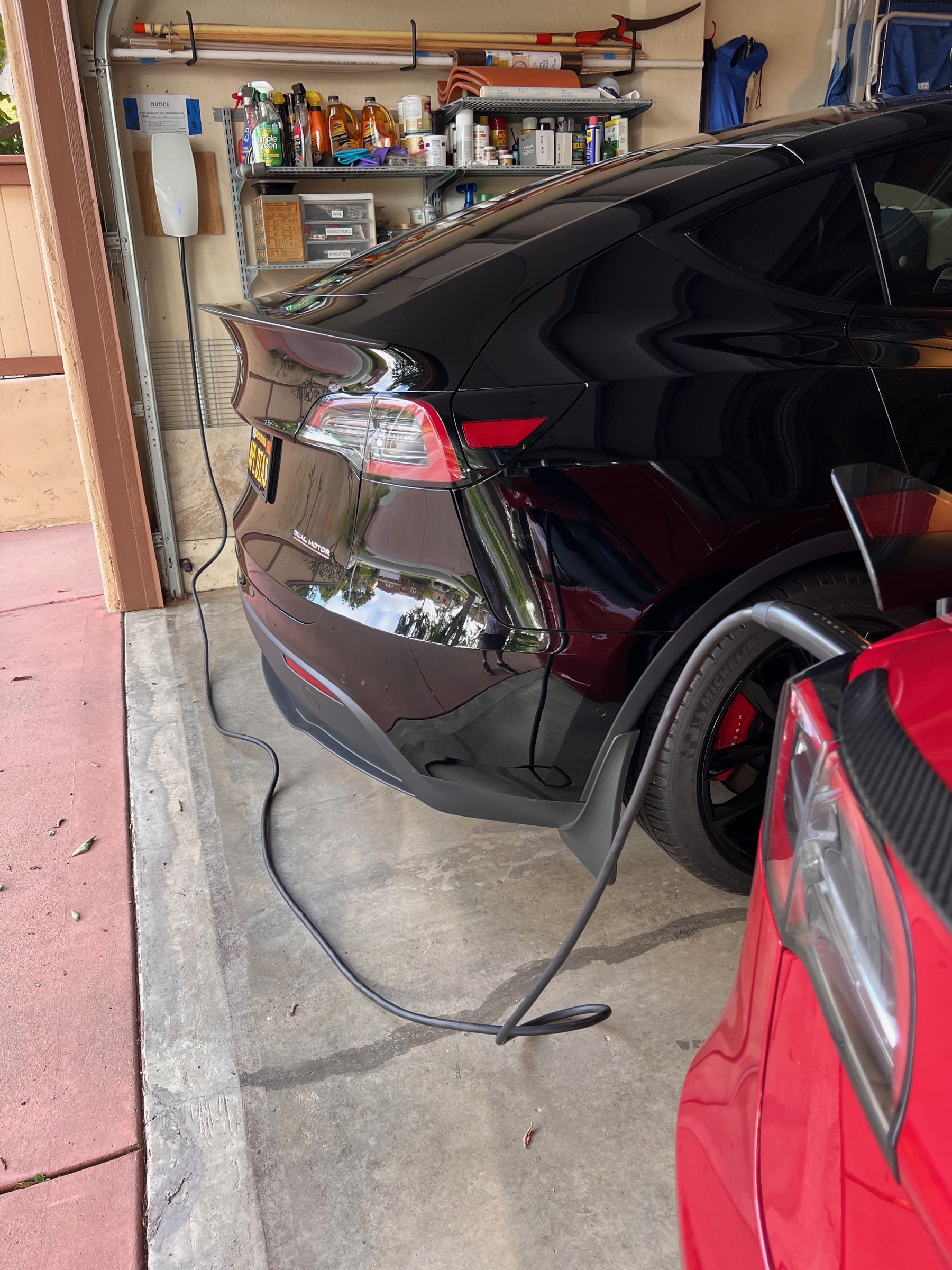 Tesla walll charger next to Steve's Black Model Y with Cable Dragged Over to My Red Model 3