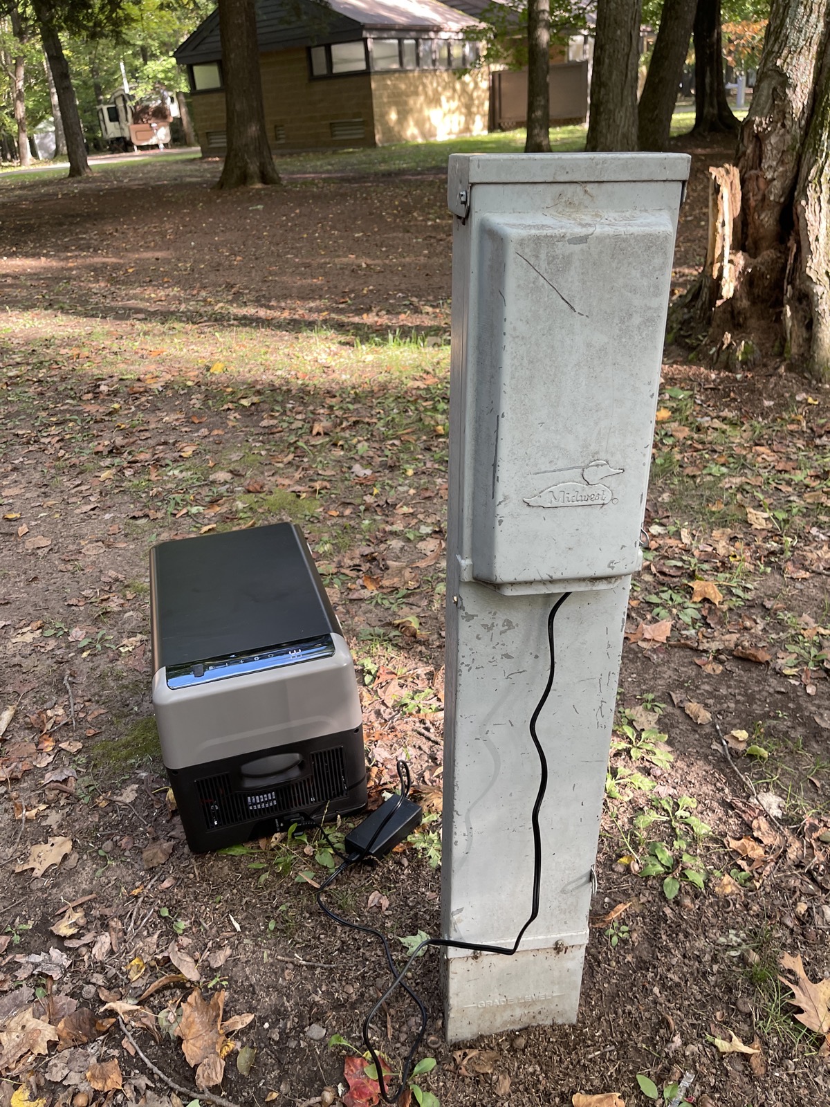 Cooler on the ground plugged into a campsite outlet