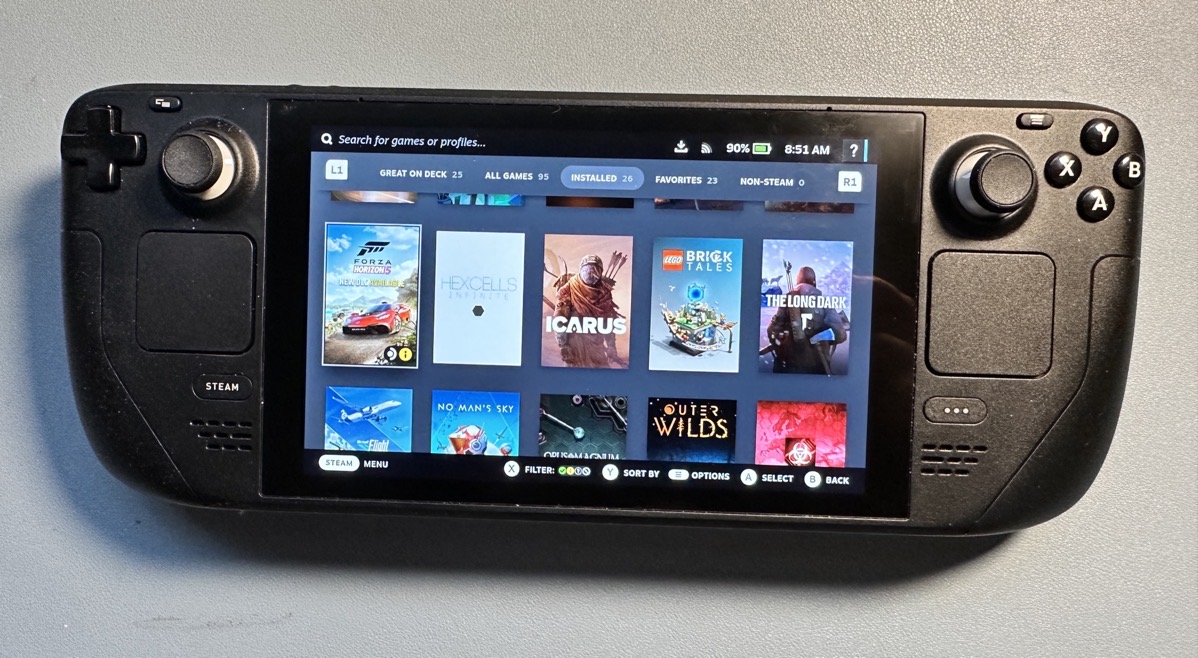 steamdeck.JPG Steamdeck with a large 16x9 screen, and buttons and control sticks on either side