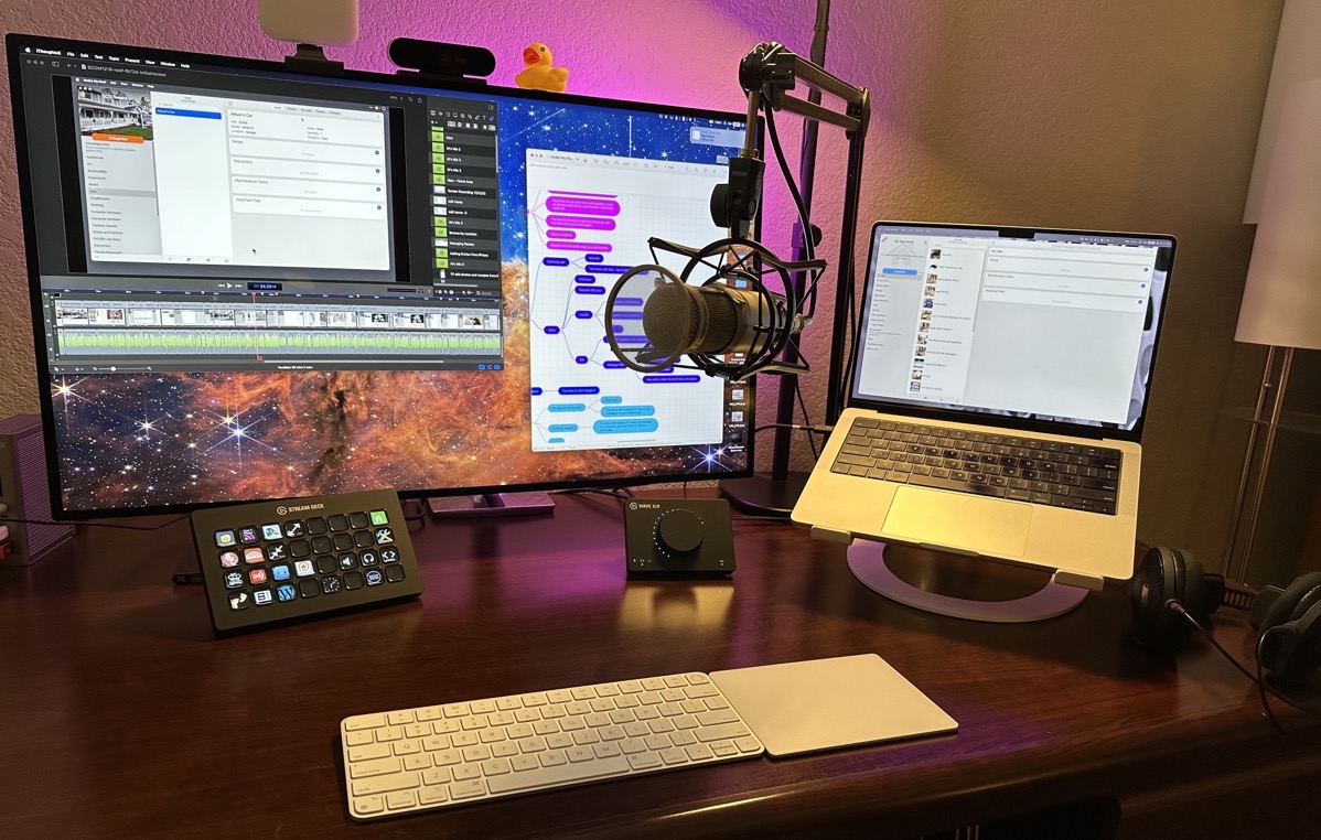 Big Display with MacBook on Stand to the Right and Mic Inbetween