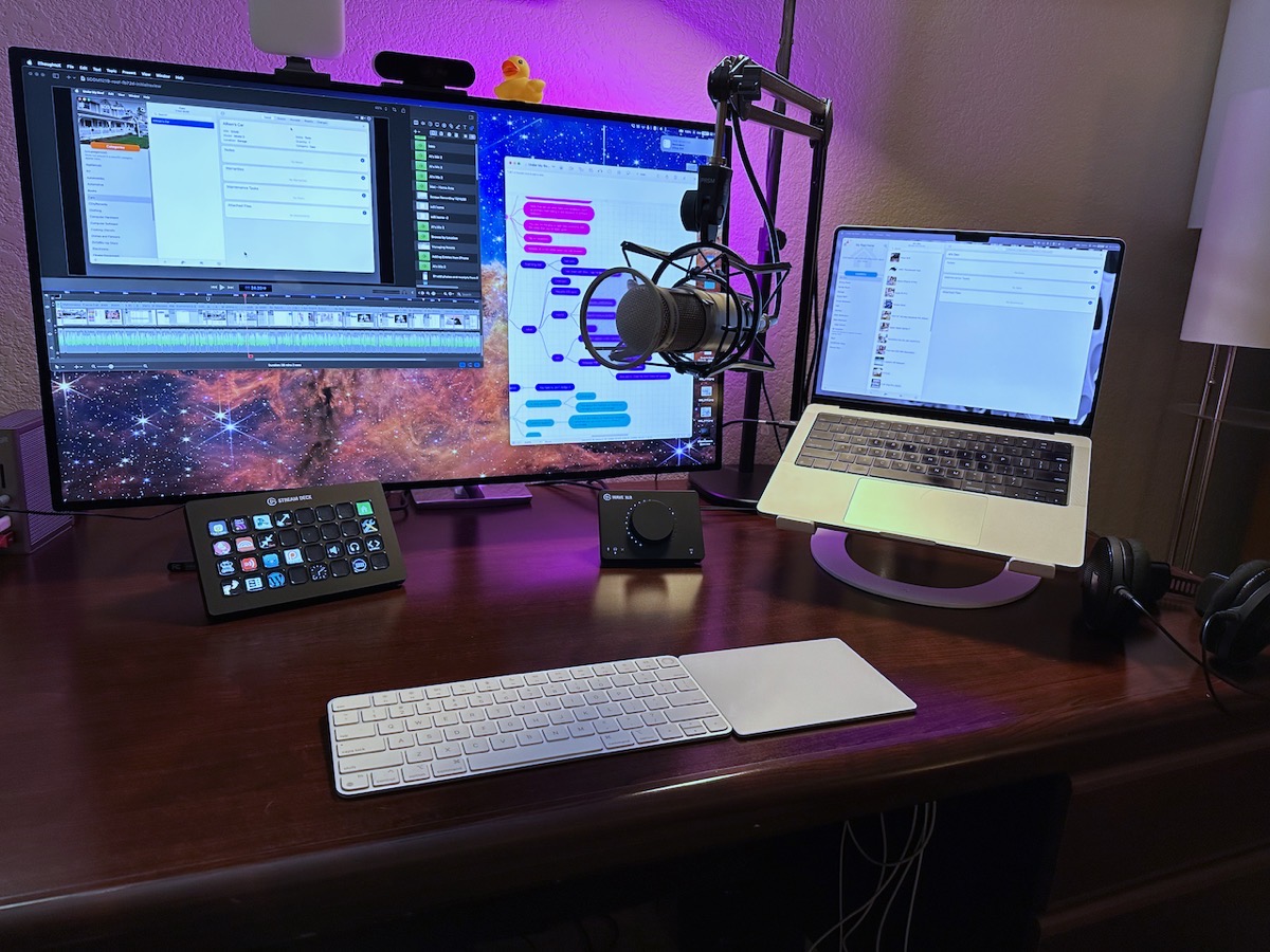 MacBook Pro on 12 South stand, Heil mic on boom arm, Elgato Wave XLR and Stream Deck (not mentioned) on the desk, Pro Display XDR with Logitech light, Logitech camera, and a rubber duck on top. Apple Magic Keyboard & Trackpad on desk