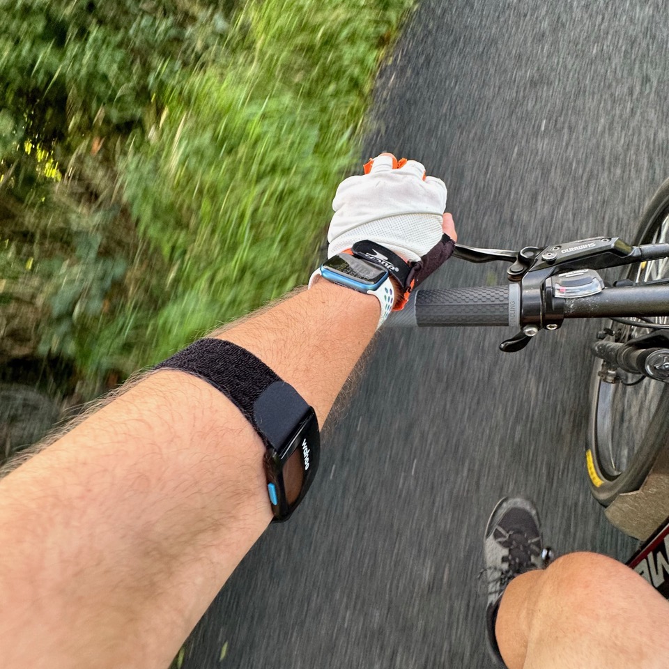 The Wahoo Trackr Fit on Bart's arm while cycling with his Apple Watch tracking the workout