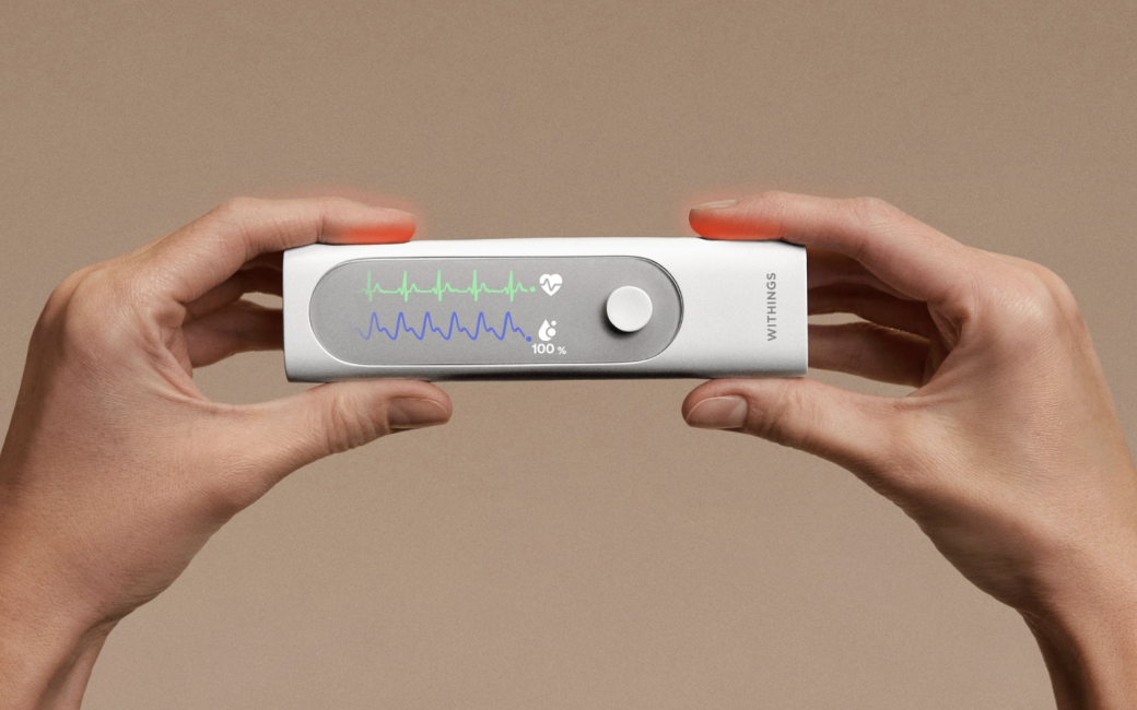 Withings BeamO device is about the size of a candy bar and is held here with a hand at each end to operate it.