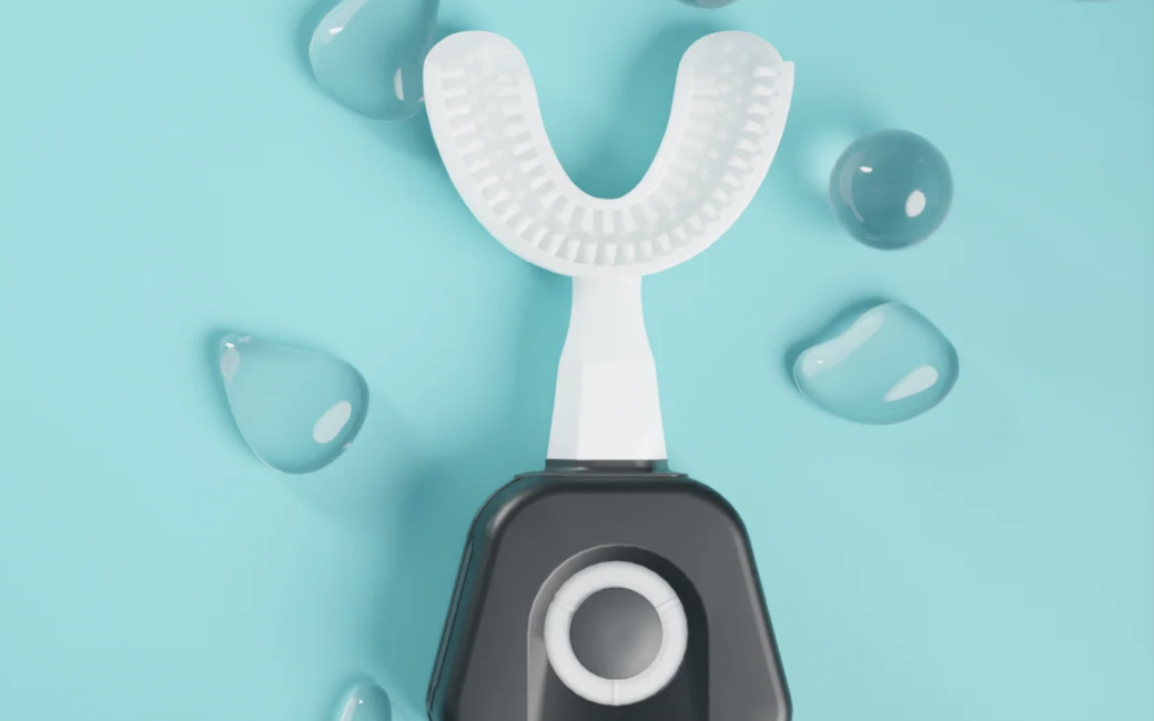 Top view of white Y-Brush tray which form fits around your teeth and has 35,000 bristles. It is attached to the black vibrating base with a button on the face to turn it on.