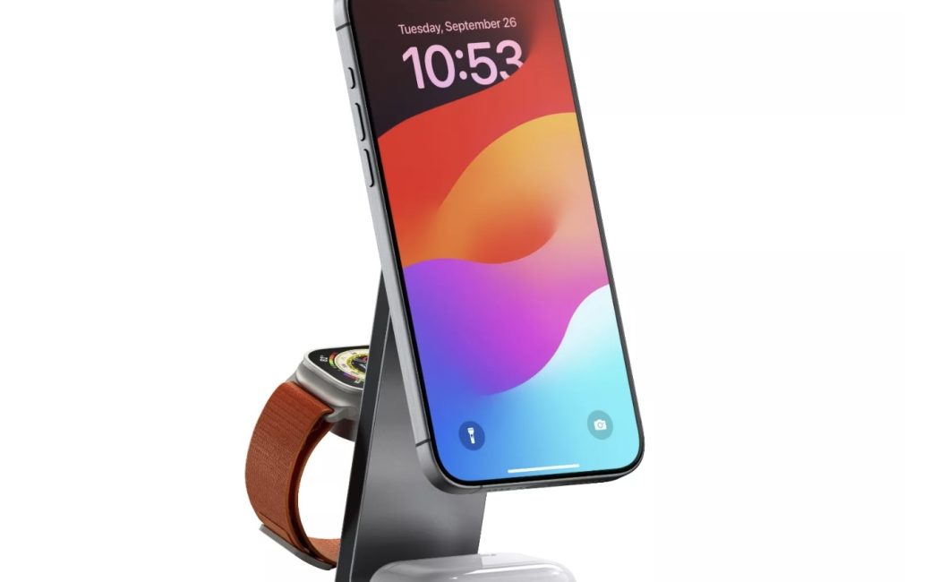Photo of the Satechi 3-in-1 Foldable Qi2 Charging Stand showing an iPhone mounted vertically, AirPods charging on the base, and an Apple Watch on the back sitting on charging puck.