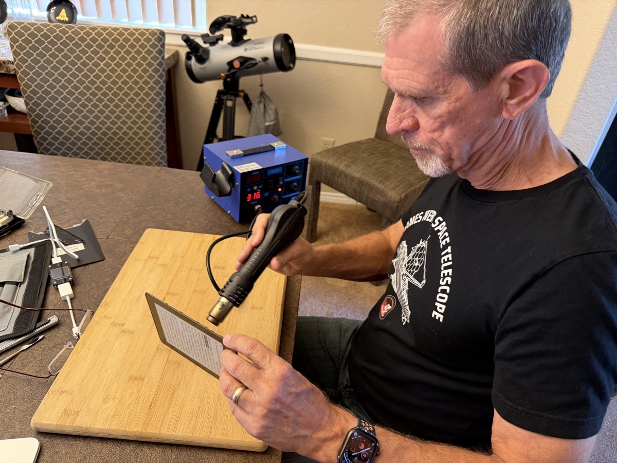 Steve with heatgun showing 316 degrees pointing it at the Kindle.