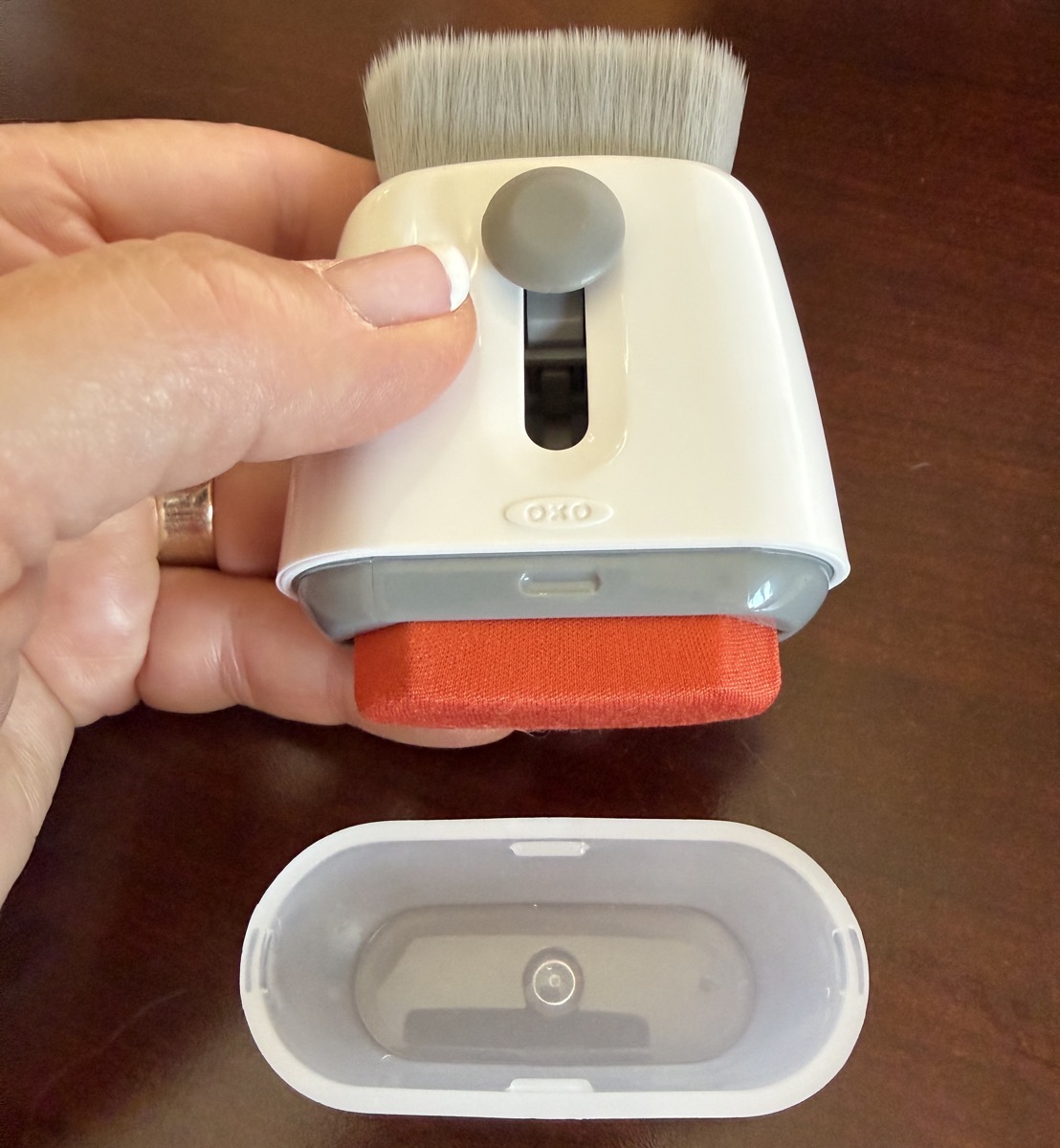 oxo sweep and swipe held in the air with the brush and cloth swiper both revealed and the plastic cover on the table.jpeg Oxo sweep and swipe held in the air with the brush and cloth swiper both revealed and the plastic cover on the table.