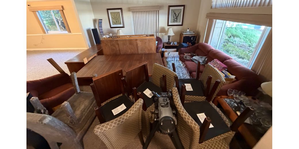 All of the furniture, glassware, and china from the dining room piled into the existing furniture of the living room. Demonstrates the level of chaos.