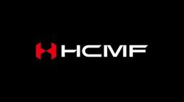 Black rectangular logo with a bold red abstract ‘H’ symbol on the left and the white capital letters ‘HCMF’ in a modern sans‑serif font on the right.