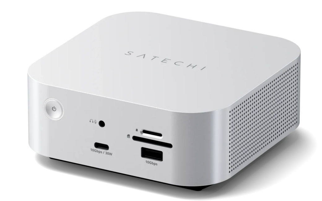 A silver compact desktop mini dock/hub branded “SATECHI,” shown at an angle on a light gray background. The front panel includes a power button, headphone jack, USB-C port labeled 10Gbps/30W, SD and microSD card slots, and a USB-A port labeled 10Gbps. Perforated ventilation holes cover the right side panel.