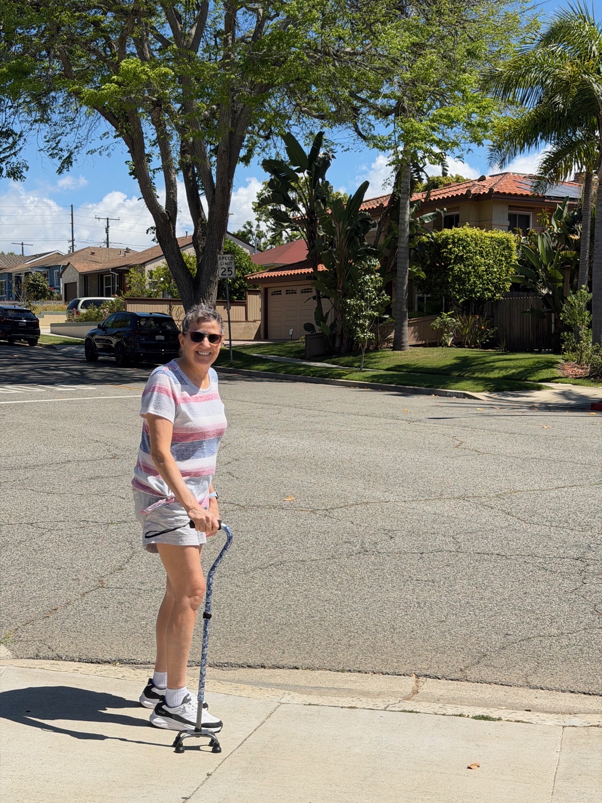 Allison walking with a cane outside our house.