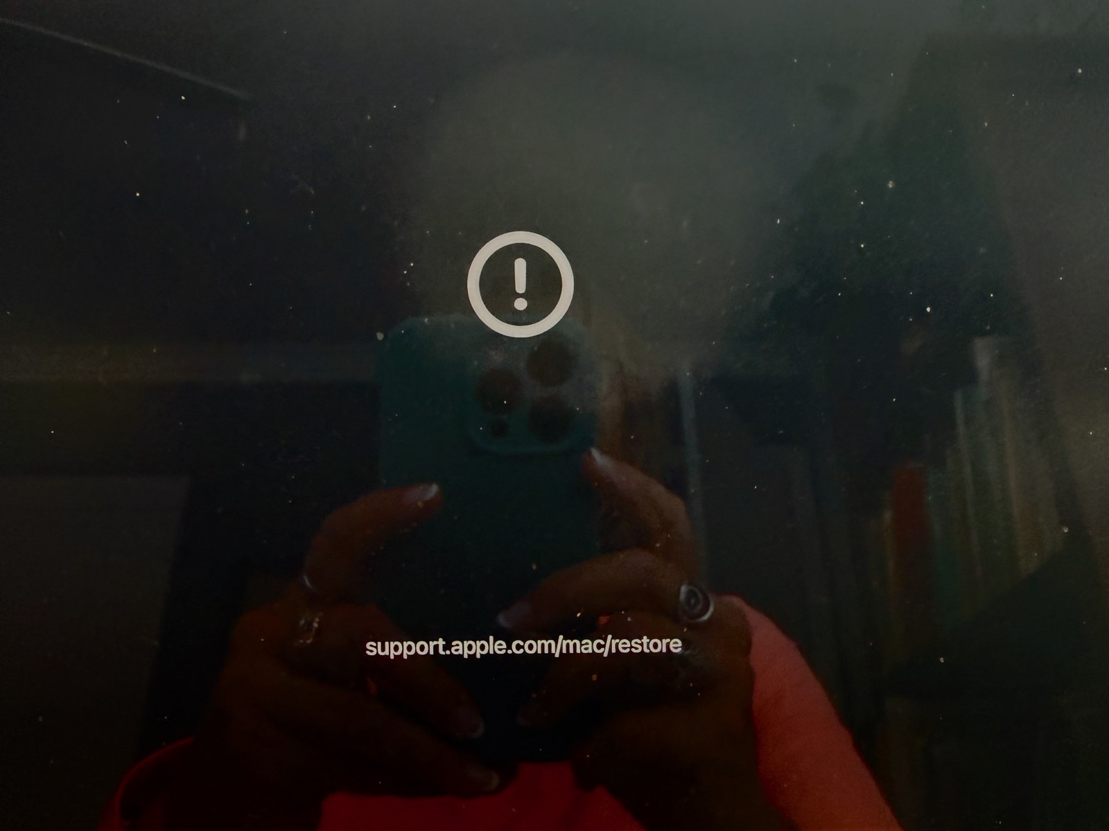 Photo of mac screen with exclamation point and url to restore at apple support.