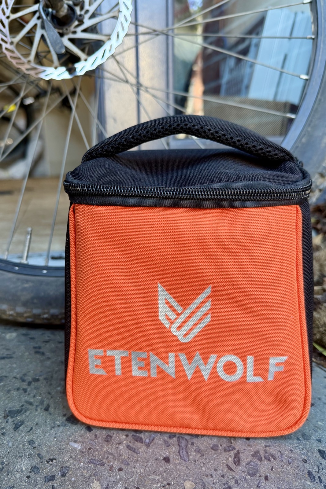 NCXXXX-Review-EtenWolfZephyrS3-Photo1.jpeg bright orange square case with a black zipper top and handle