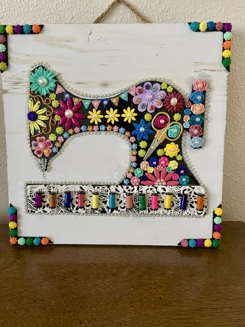 Antique sewing machine wood wall hanging. the sweing machine is made with different colored beads.